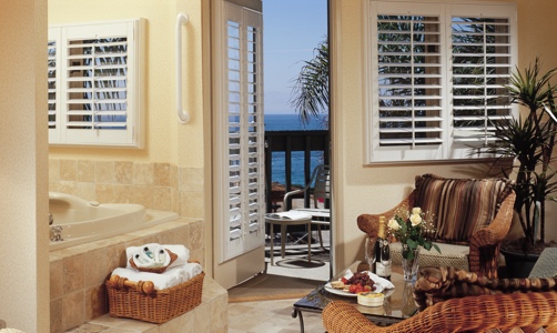 Plantation shutters on casement windows in a oceanfront home.